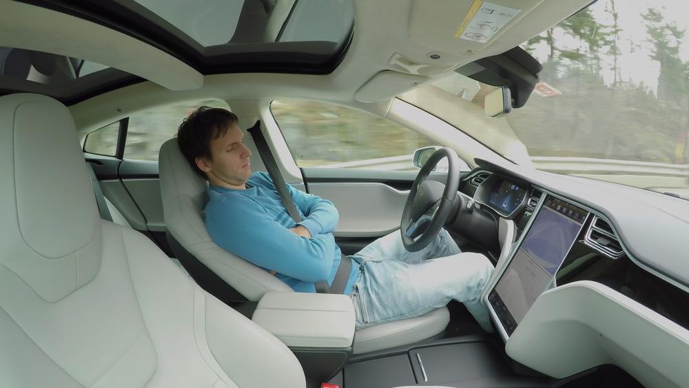 man sleeping in autonomous car